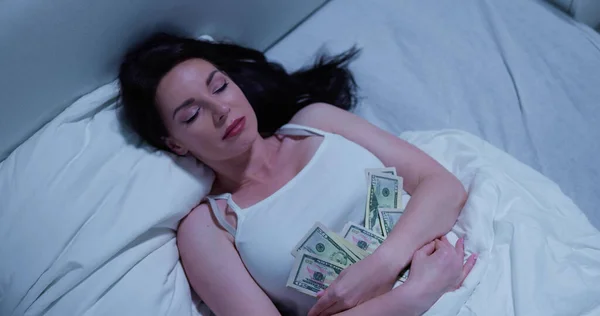 Woman Sleeping On Bed With Bundle Of Currency Notes