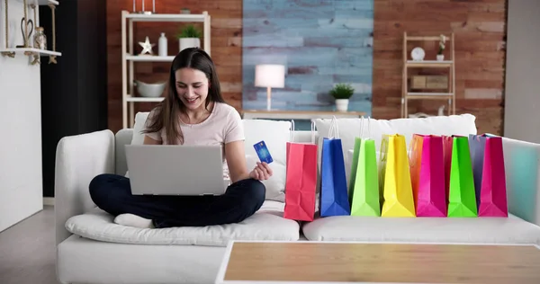 Alışveriş Kanepe Üzerinde Online Alışveriş Torbaları Ile Oturan Genç Kadın — Stok fotoğraf