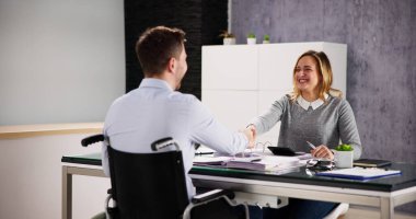 Business Man In Wheel Chair Shaking Hand In Office