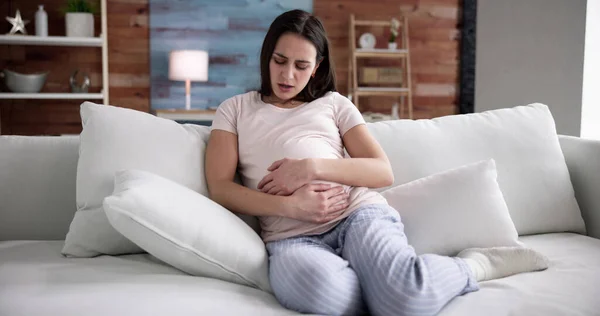 自宅で胃の痛みに苦しむ若い妊婦 — ストック写真