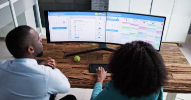 Gantt Çizelgesini Analiz Eden Genç İş Adamları ve Ofisteki Bilgisayarda Takvim