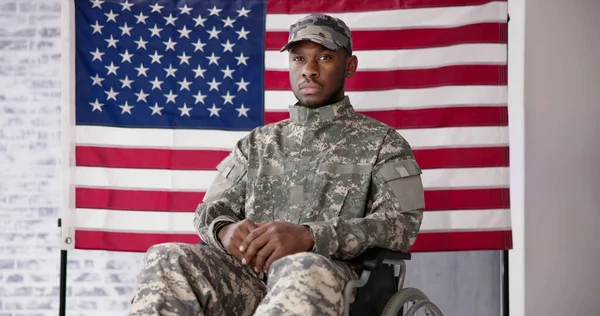 Veteran Sitting In Wheelchair In Front Of An American Flag