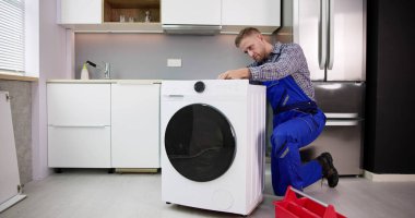 Washing Machine Repair Problem. Man Fixing Appliance
