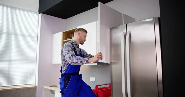 Male Carpenter Assembling White Cabinet Wall Kitchen —  Fotos de Stock