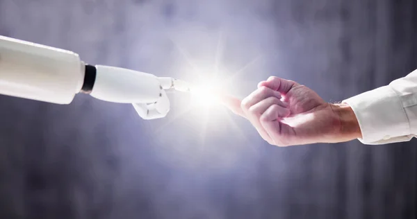 Roboter Berührt Menschlichen Finger Vor Grauem Hintergrund — Stockfoto