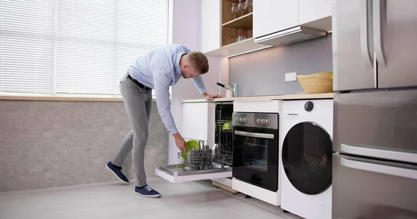 Happy Man Arranging Plates Dishwashing Machine Kitchen — Foto de Stock