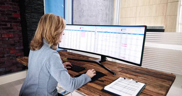 在电脑上使用电子表格进行数据分析的妇女 — 图库照片