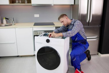 Washing Machine Repair Problem. Man Fixing Appliance