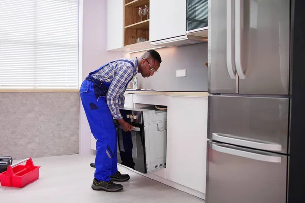 Male Worker Repairing Oven Appliance Kitchen Room — Stock Photo, Image