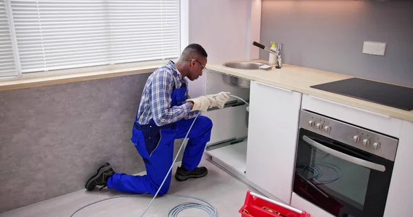 年轻的男性水管工清洗堵塞水槽管道在厨房 — 图库照片