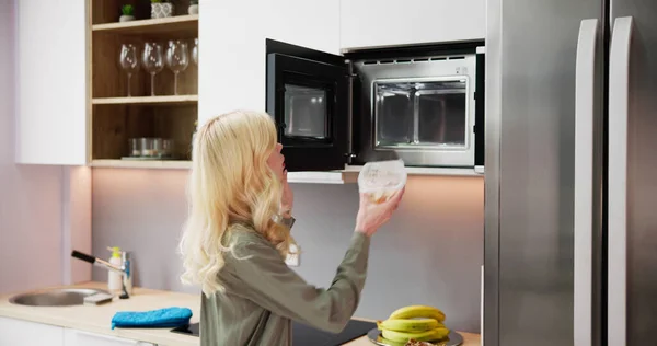 Evde Yiyecek Isıtma Için Mikrodalga Fırın Kullanan Kadın — Stok fotoğraf