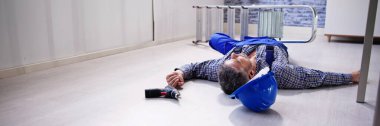 Bilinçsiz tamirci merdiven yerde yatarken ekipmanları ile üzerinden düşmüş