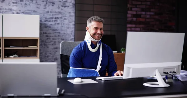 骨折的胳膊受伤事故 在办公室使用电脑的人 — 图库照片
