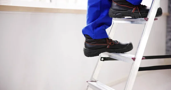 Man Climbing Step Ladder In Safety Shoes