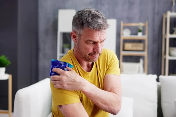 Man Applying Cool Gel Pack His Shoulder — Stok fotoğraf