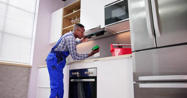 年轻修理工修理厨房萃取器滤波器在厨房的房间 — 图库照片