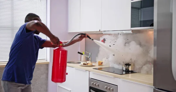 Man Using Fire Extinguisher Stop Fire Burning Cooking Pot Kitchen — Stock Photo, Image