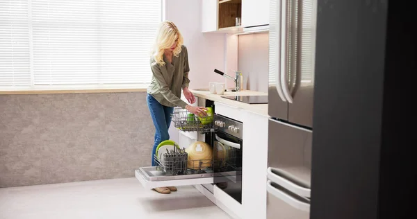 Щаслива Молода Жінка Організовує Тарілки Посудомийній Машині Будинку — стокове фото