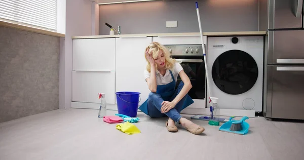 Frustrierte Junge Frau Sitzt Auf Küchenboden Und Betrachtet Putzmittel Hause — Stockfoto