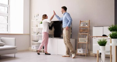 Genç çift yeni televizyon evde taşıyan gülümseyen