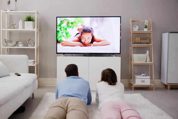 Mladý Pár Dívat Televizi Zatímco Sedí Pohovce Obýváku Doma — Stock fotografie