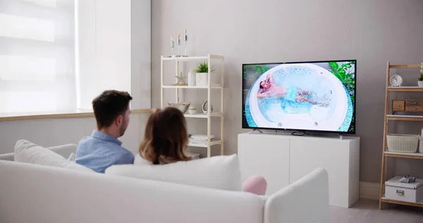 Junges Paar Sitzt Auf Couch Und Schaut Fernsehshow — Stockfoto