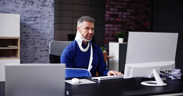骨折的胳膊受伤事故 在办公室使用电脑的人 — 图库照片