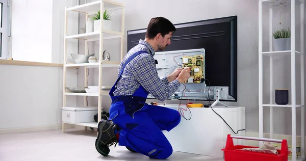 Young Male Electrician Overall Checking Television — Stock Photo, Image