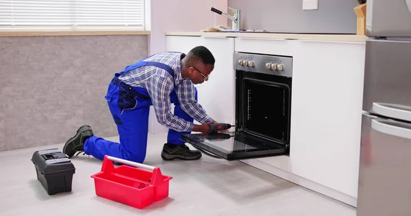 Male Worker Repairing Oven Appliance Kitchen Room — Stock Photo, Image