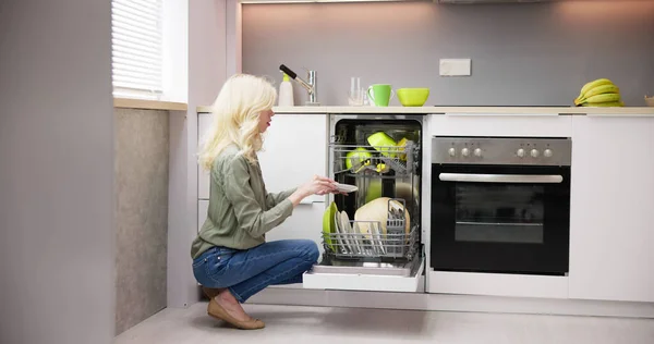 Happy Young Woman Arranging Plates Dishwasher Home — Stock Photo, Image