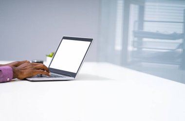 İş yerindeki laptopta çalışan bir adamın yakın çekimi