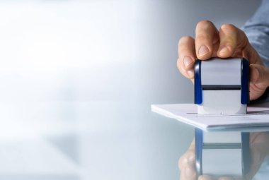 Bir birinin elini masanın üzerinde onaylanmış başvuru formunda damgalama Close-Up