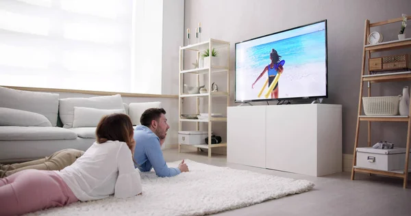 Mladý Pár Dívat Televizi Zatímco Sedí Pohovce Obýváku Doma — Stock fotografie