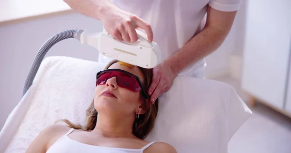 美容师应用激光治疗妇女面部感染 — 图库照片