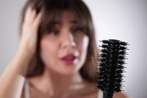 Молода Жінка Халаті Тримає Гребінець Дивлячись Випадання Волосся Вдома — стокове фото