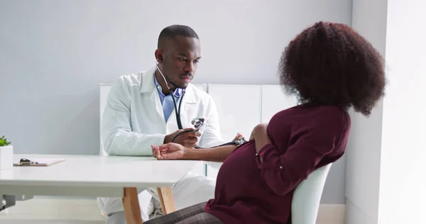 Male Doctor Measuring Blood Pressure Pregnant Woman Clinic —  Fotos de Stock