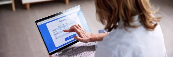 Woman Looking At Online Computer Survey Or Feedback