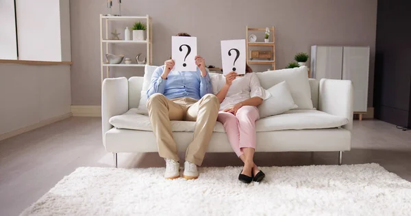 Couple Sitting Sofa Holding Question Mark Sign Front Face — Stock Photo, Image