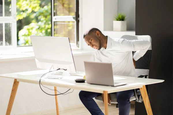 アフリカ系アメリカ人男性 悪い姿勢から仕事で腰痛 — ストック写真