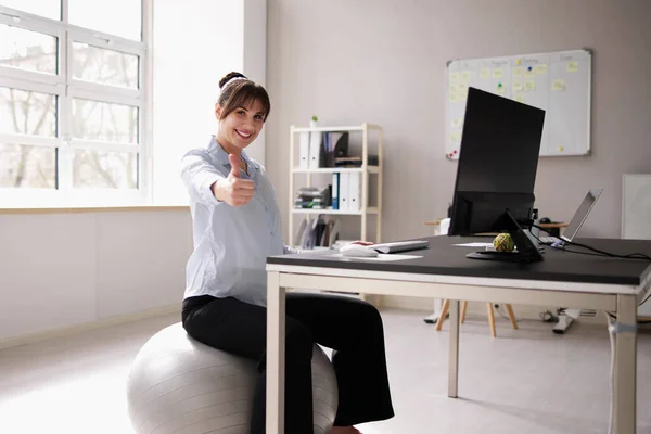 Woman Sitting On Gym Ball In Office. Correct Posture
