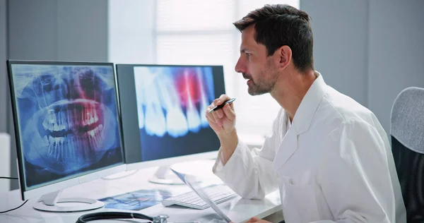 デスクトップコンピュータ上のX線ソフトウェアを使用して放射線科歯科医師 — ストック写真