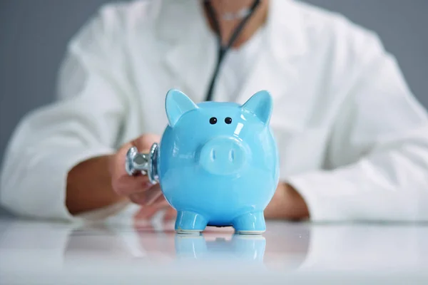 Lekarz Badający Oszczędności Piggybank Pomocą Stetoskopu — Zdjęcie stockowe
