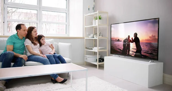 Młoda Rodzina Ogląda Razem Telewizję Domu — Zdjęcie stockowe