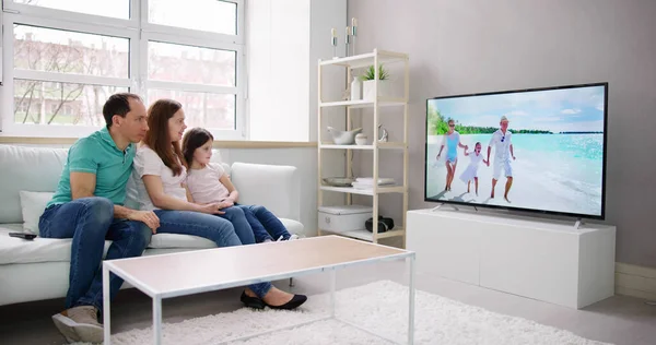 Evde Birlikte Televizyon Izleyen Genç Bir Aile — Stok fotoğraf