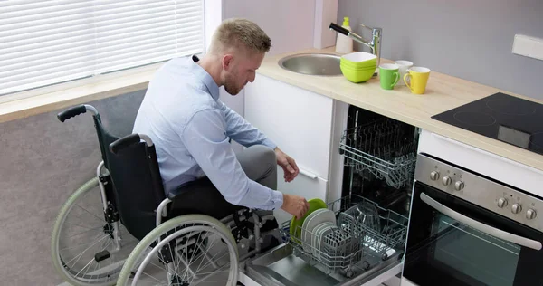 Человек Ограниченными Возможностями Инвалидной Коляске Помощью Посудомоечной Машины Кухне — стоковое фото