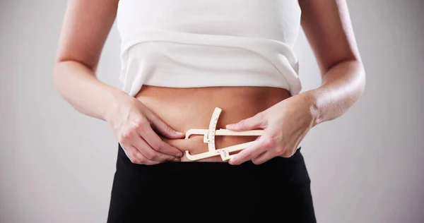 女性の手測定脂肪腹で脂肪キャリパー — ストック写真