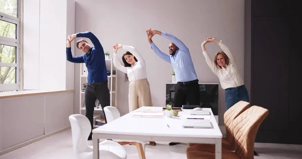 Tevreden Ondernemers Doen Stretching Oefening Achter Bureau Werkplek — Stockfoto