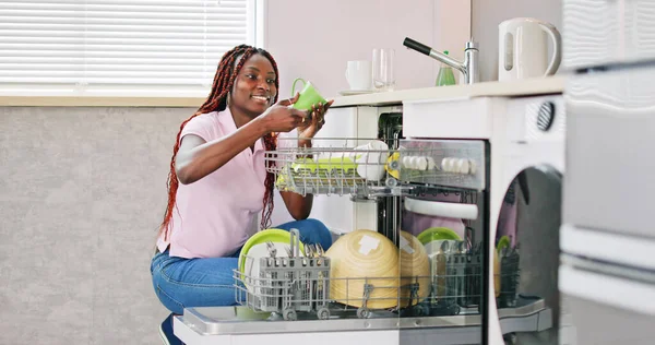 年轻快乐的女人在家里安排板放入洗碗机 — 图库照片