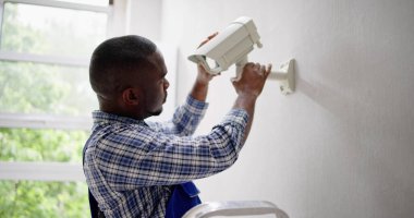 Duvardaki kapalı devre kamerayı ayarlayan teknisyenlerin yakın çekimi