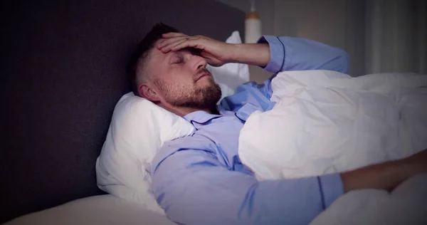 不眠症のベッドで目を覚ます男 眠りの悪夢 — ストック写真